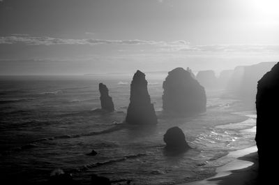 Rocks on sea against sky during sunset