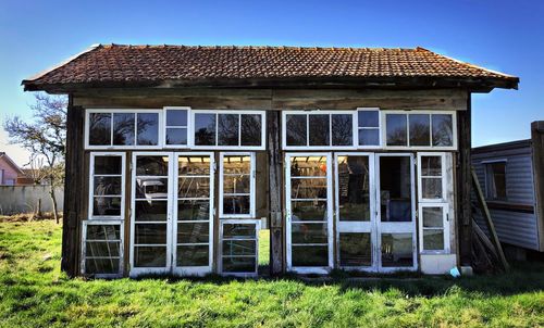 Exterior of old house on field against clear sky