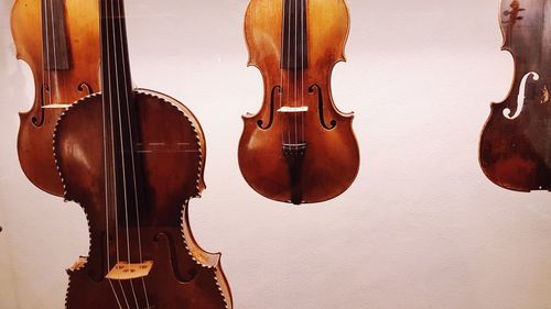 Close-up of violins against white wall