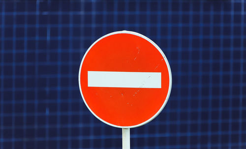 Close-up of do not enter sign against blue wall