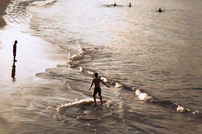 Family at the beach, golden hour, kids playing