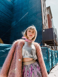 Portrait of a smiling girl standing against building
