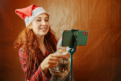 Portrait of smiling woman holding camera