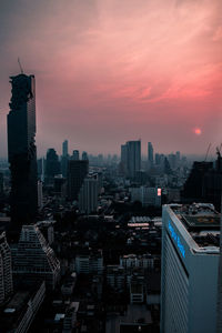 Aerial view of modern buildings against sky during sunset