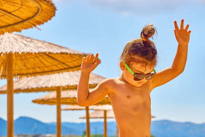 Close-up of a girl against holding umbrellas at beach