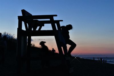 Silhouette people standing against clear sky during sunset
