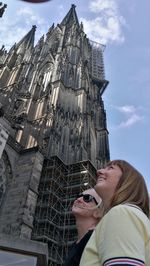 Low angle view of women against building and sky