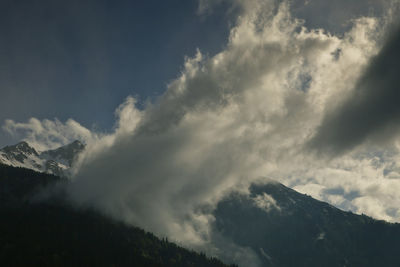 Low angle view of snowcapped mountains against sky