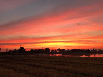 Scenic view of field against romantic sky at sunset