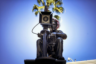 Low angle view of statue against blue sky