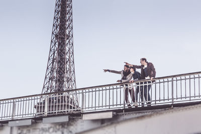 Low angle view of people on bridge against sky