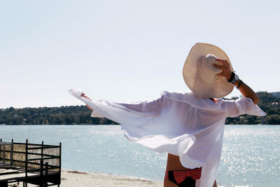 Back view of woman enjoying the view at he beach in summer.