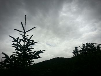 Low angle view of mountain against cloudy sky