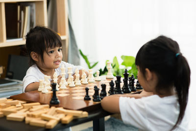 Siblings playing chess at home