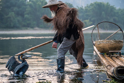 Man with bird fishing in lake