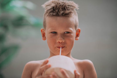 Close-up portrait of boy holding camera