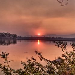 Scenic view of lake against orange sky