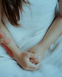 Midsection of girl with bruise on hand