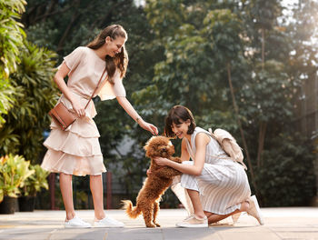 Side view of woman with dog on field