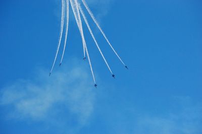 Low angle view of airshow against blue sky