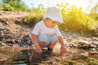 Baby boy spending leisure time at river