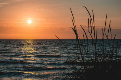 Scenic view of sea against romantic sky at sunset