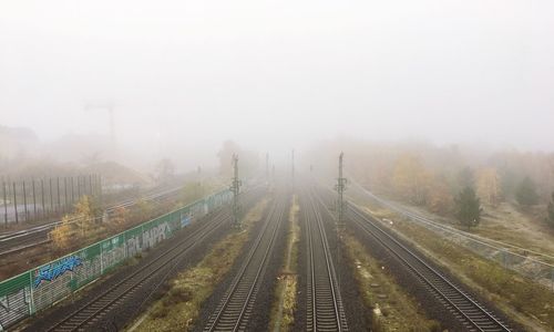 Railroad tracks against sky during foggy weather
