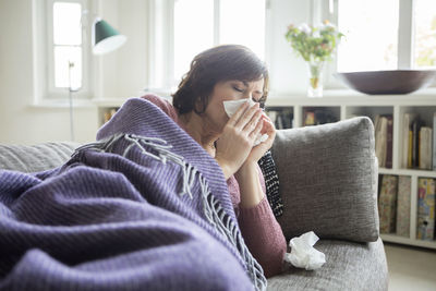 Woman having a cold lying on the sofa