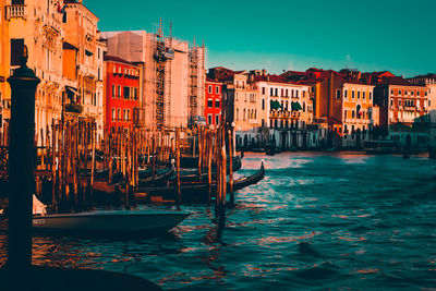 Boats in canal by buildings in city