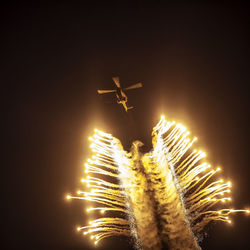 Low angle view of firework display against clear sky at night