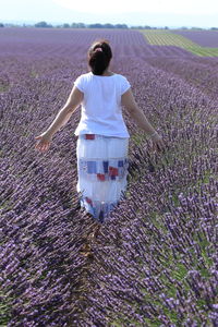 Rear view of woman standing amidst lavender