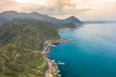 High angle view of sea and mountains against sky