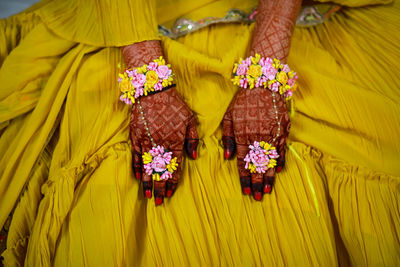 Close up of bride hands with flowers on his fingers 