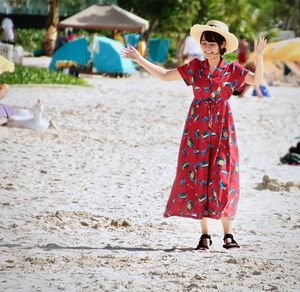 Woman with arms raised on beach