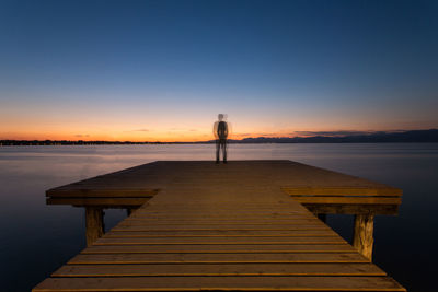 Pier over sea against romantic sky at sunset