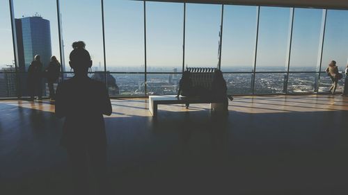 Rear view of people standing in city building