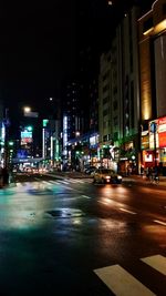 Illuminated city street and buildings at night