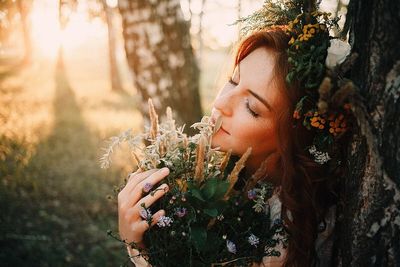 Portrait of beautiful woman by flower plants