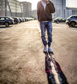 Low section of man walking on road