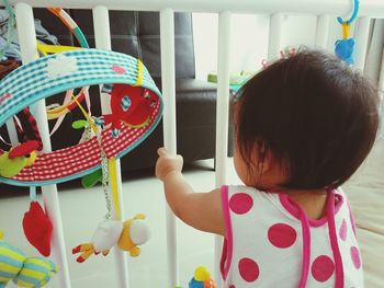 Rear view of girl with toy toys