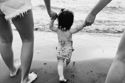 Family holding girl at beach