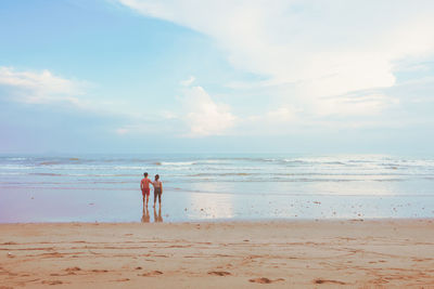 Happy romantic couple enjoying beautiful sunset walk on the beach. pastel colors tone