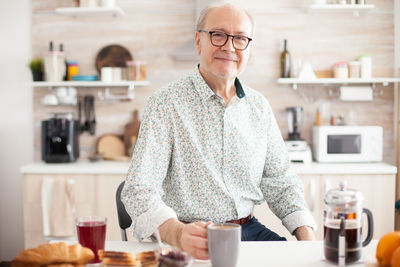 Portrait of smiling man standing at home