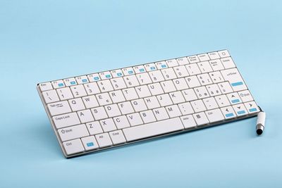 High angle view of computer keyboard against blue background