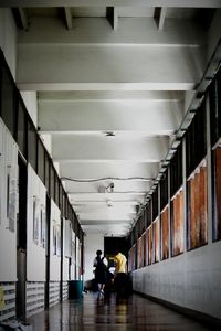 People walking in illuminated corridor