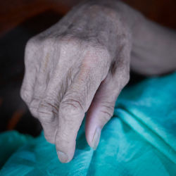 Close-up of woman hand on bed