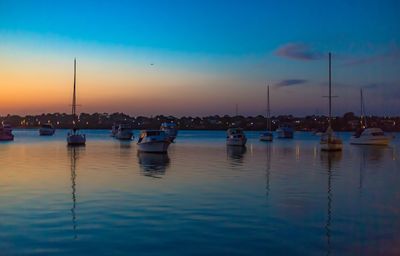 Sailboats in marina at sunset