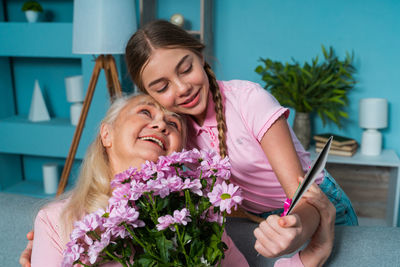 Happy girl giving bouquet to grandmother at home