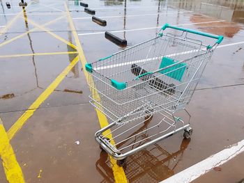 High angle view of empty shopping cart on wet footpath