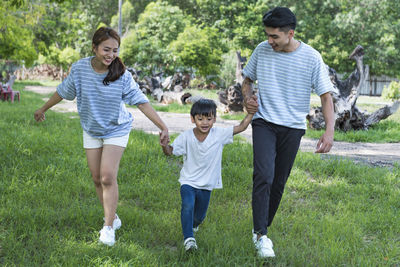 Full length of siblings walking on field